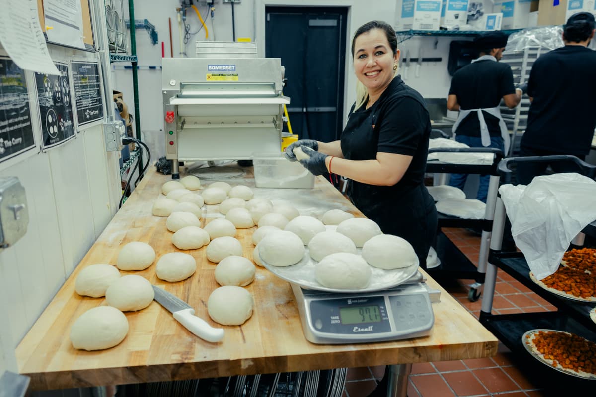 Curry Pizza staff preparing fresh dough for catering